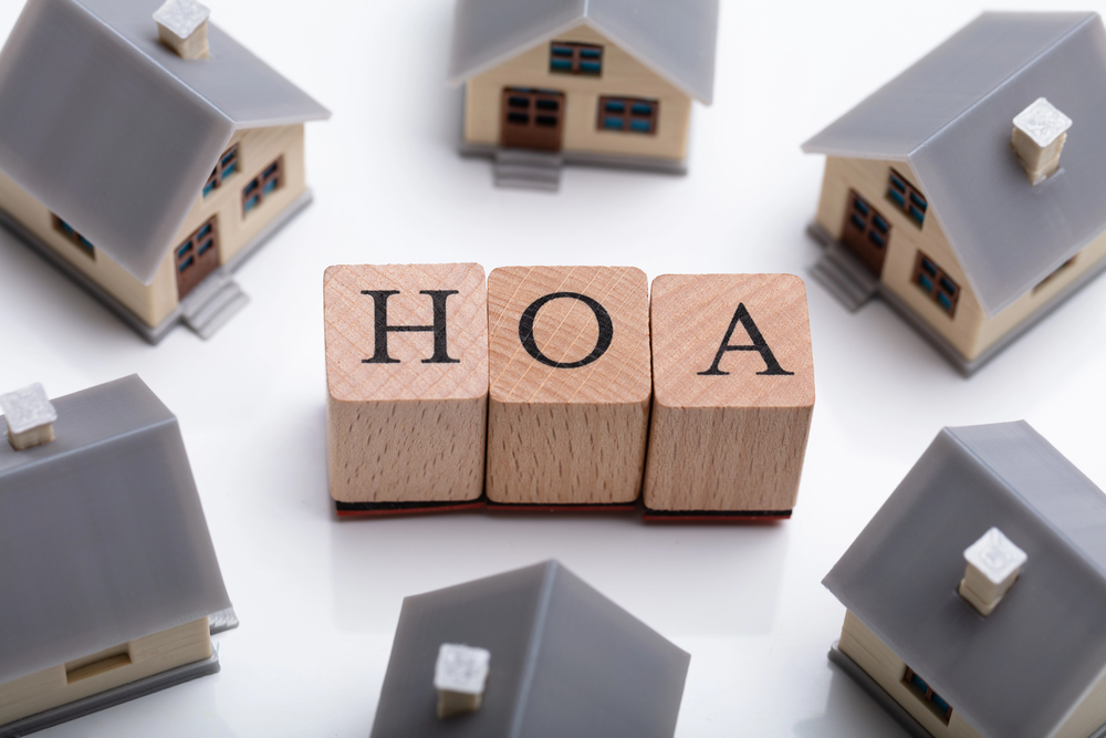 Blocks spelling HOA surrounded by model houses.