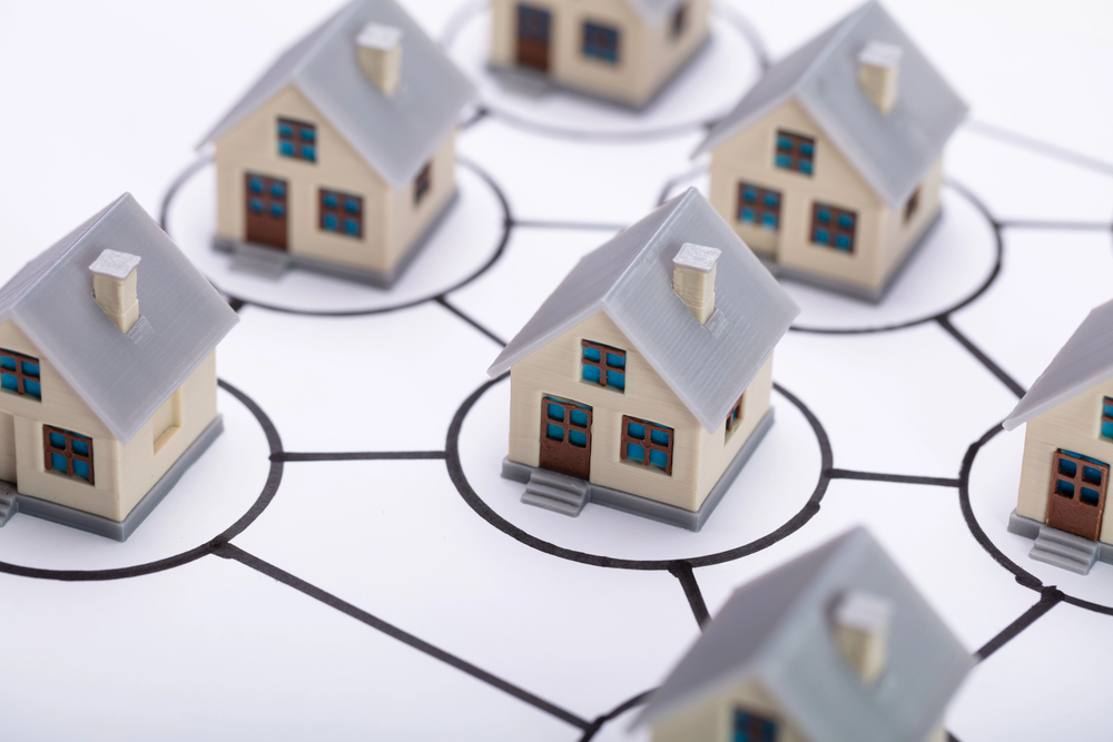 Network of miniature houses connected on paper map.